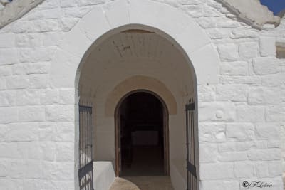 L'interno della basilica è formato da una navata centrale e due laterali che comunicano tra loro attraverso archi a sesto leggermente acuto. Le volte a botte hanno sagoma e struttura analoghe alle sezioni verticali del trullo.Al centro domina il dipinto della Madonna con Bambino e Santi (San Pietro e papa Gregorio Magno) centrata su un altare ligneo del XVII secolo.