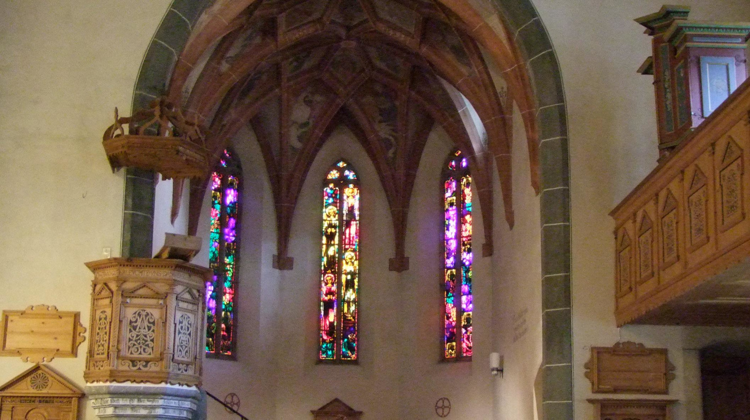 Die Kirche St. Jakob mit Blick in den Chor mit den Glasfenstern von Augusto Giacometti (Bild W. Bstieler).