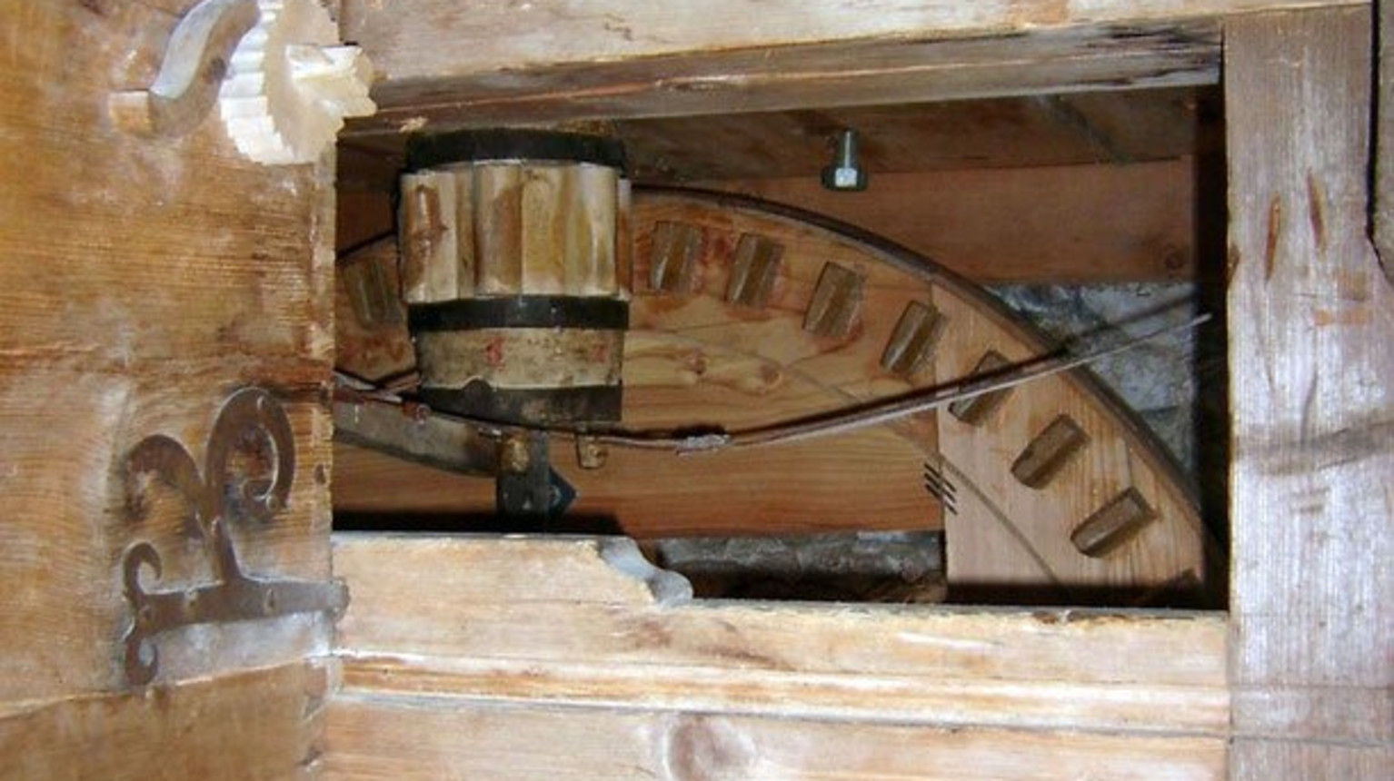 View inside the mill with hopper, wooden vat, and millstone.