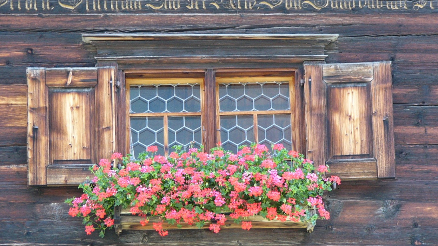 Detailed view with house motto and the windows with an imitation of the so-called bull's eye panes on the Florin house (photo Pro Serneus, 2016).