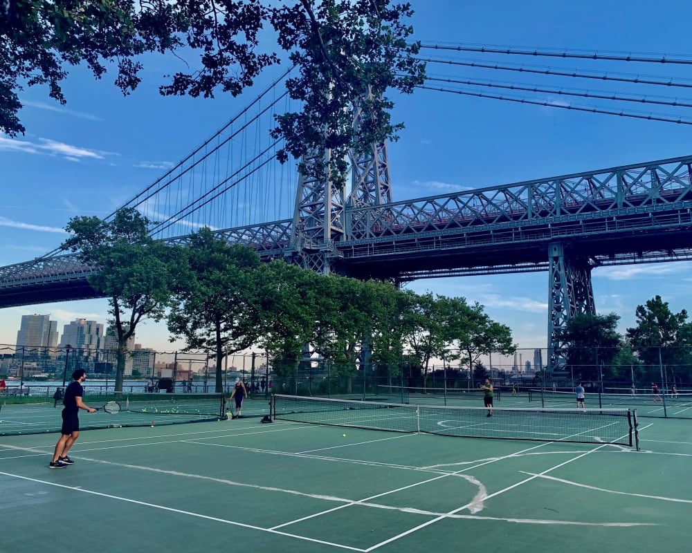 Brooklyn Bridge Park's waterfront lawns with the Manhattan skyline across the East River