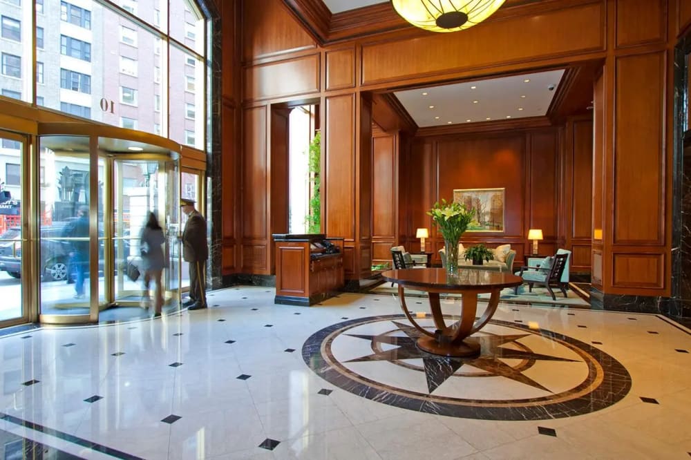 Grand lobby of a luxury Manhattan cooperative building with marble floors and white-glove doorman service