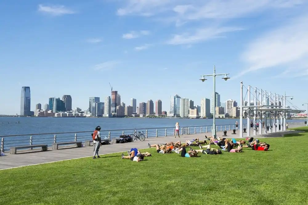 Cyclists and sunbathers along the Hudson River Greenway piers on Manhattan's west side