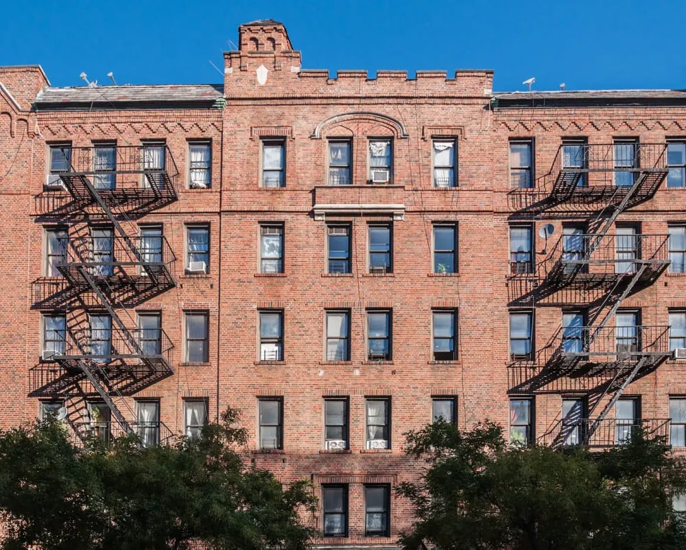 Row of classic prewar apartment buildings on a Manhattan street with brick facades and ornate architectural details
