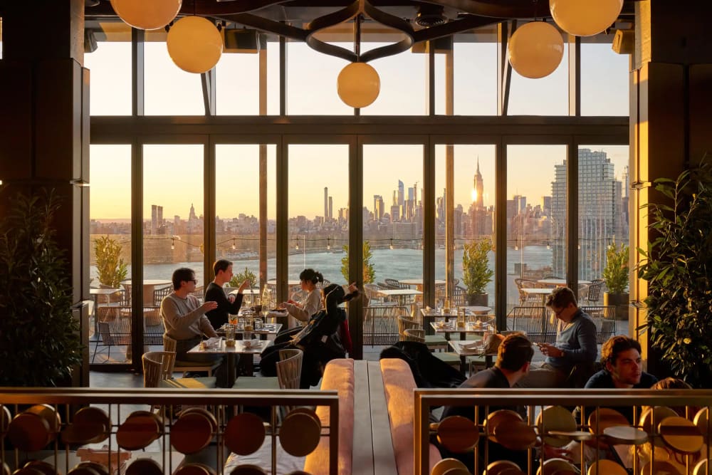 Manhattan skyline view across the East River from a Williamsburg rooftop lounge at night