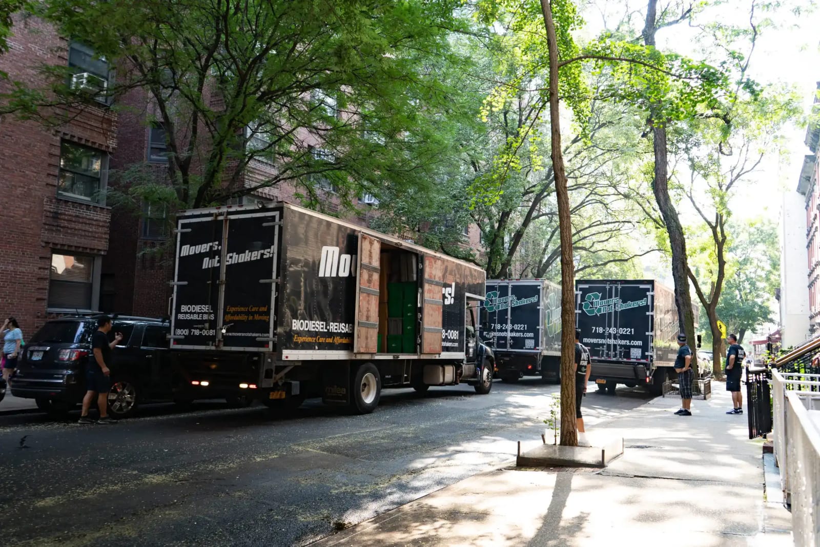 Moving truck on a quiet NoMad side street, boxes going up a stoop, converted prewar loft buildings behind