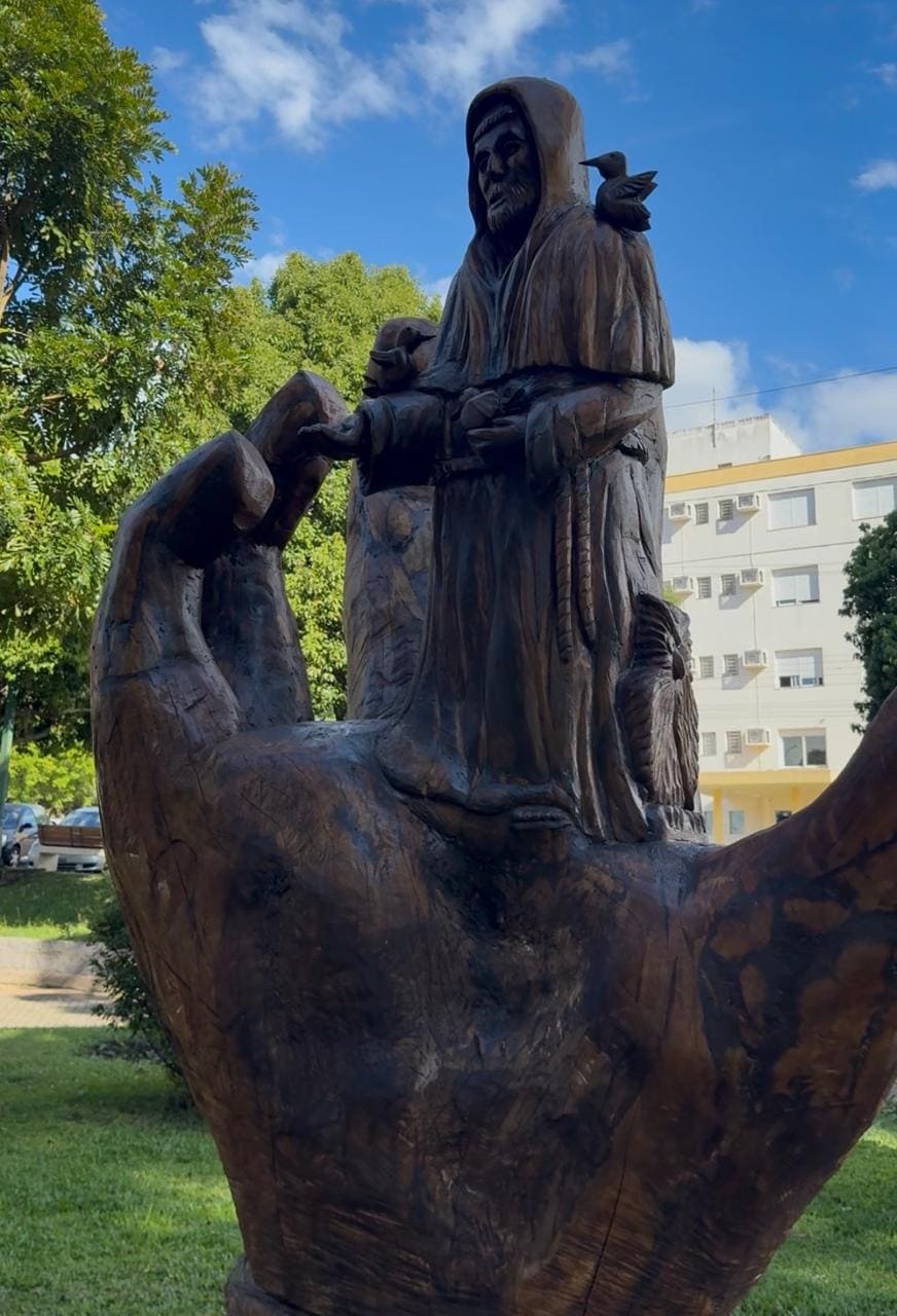 Escultura esculpida em madeira com a imagem de uma mão segurando São Francisco de Assis - São Marcos (RS)
