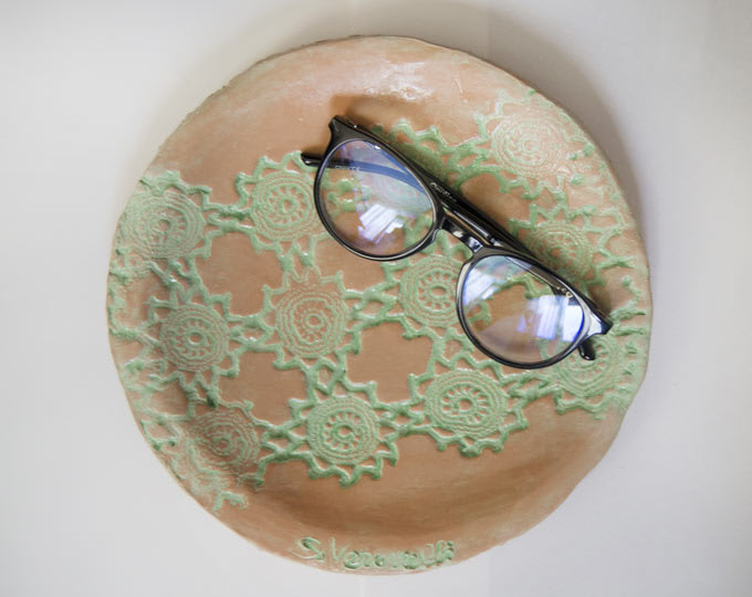 Red clay plate with colored lace design with green engobe
