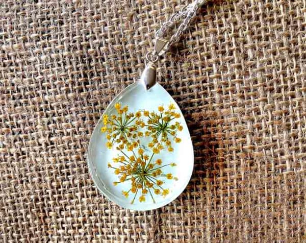 $30 shipped #yellow #queenanneslace #handdriedflowers #handmade #teardrop #pendant #white background hung on #silver #chain #resinart #resi…