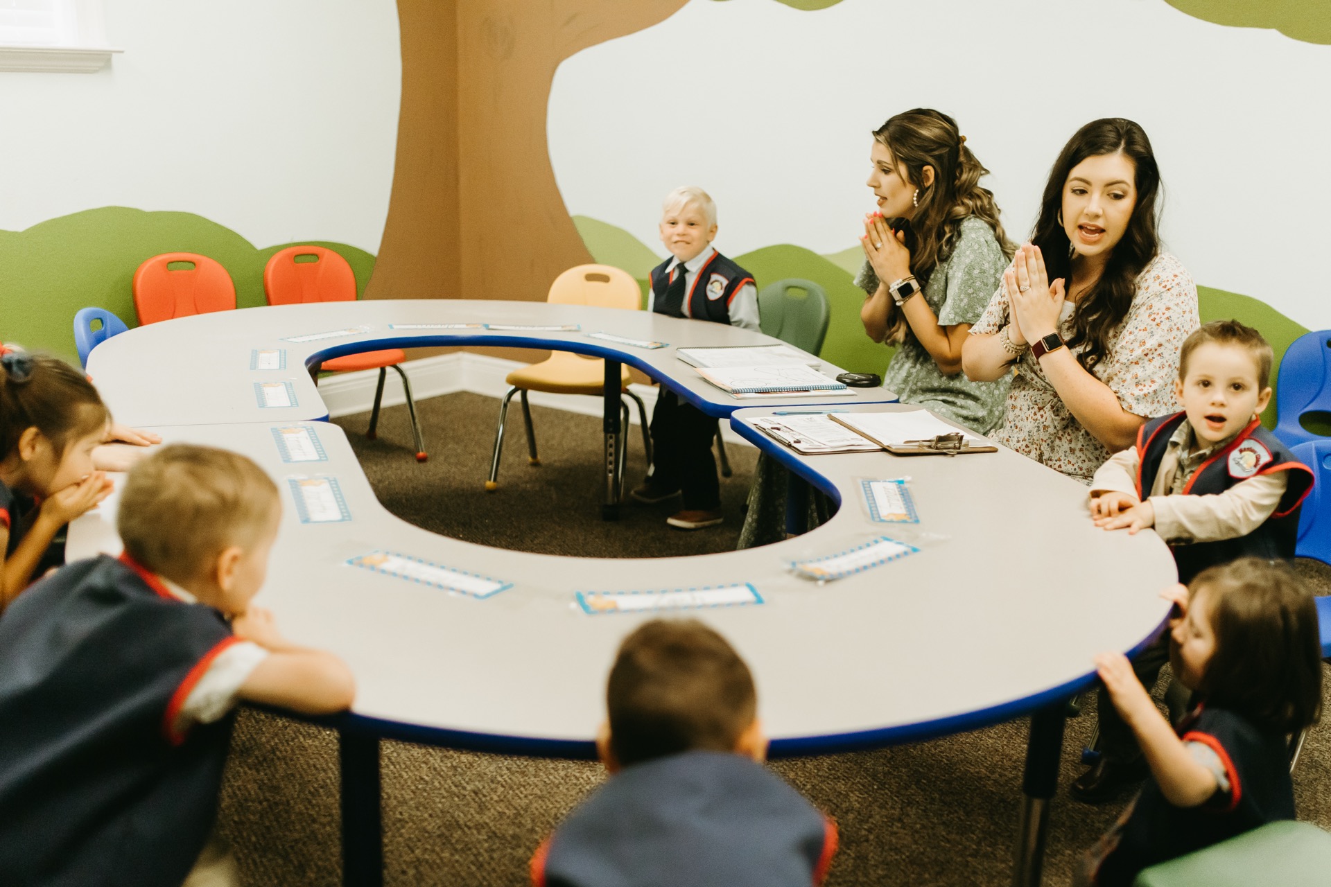 Young children at table with teachers