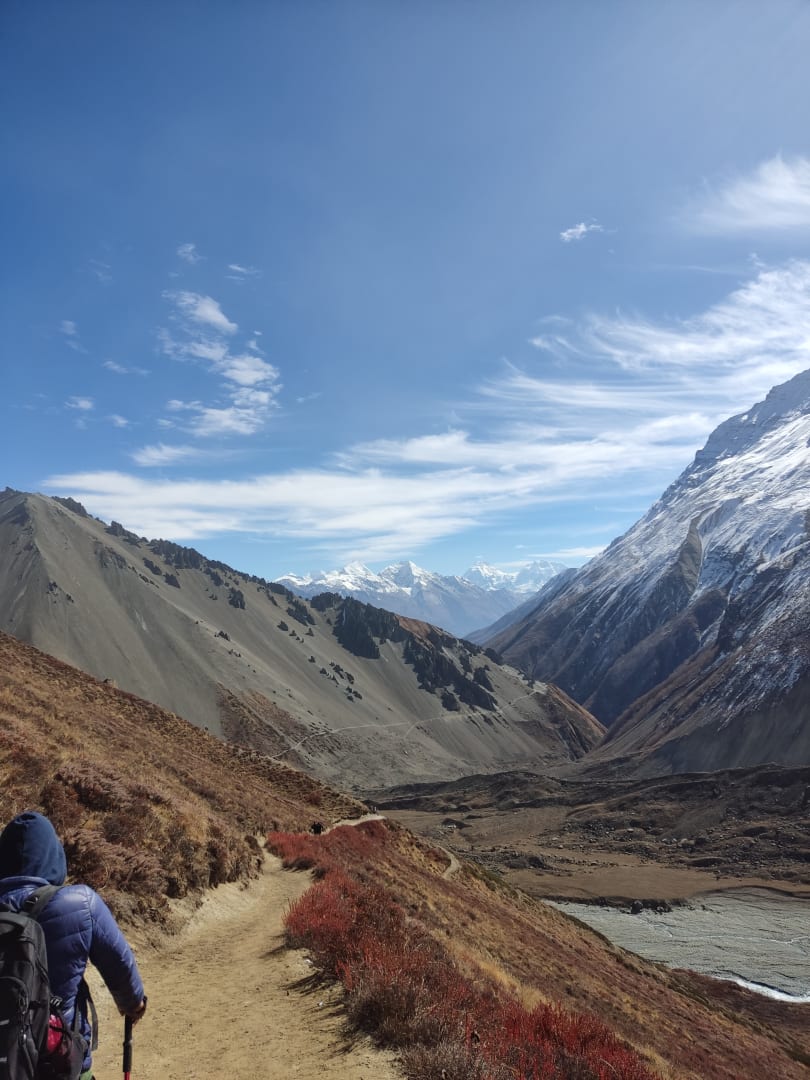 Trekkers on a Himalayan trail with prayer flags