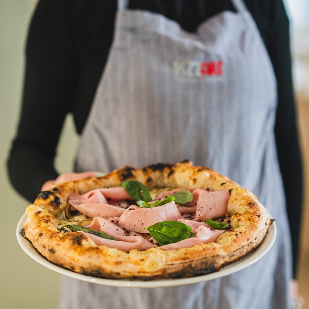 Il pizzaiolo Pizz'Art presenta una pizza con mortadella e basilico