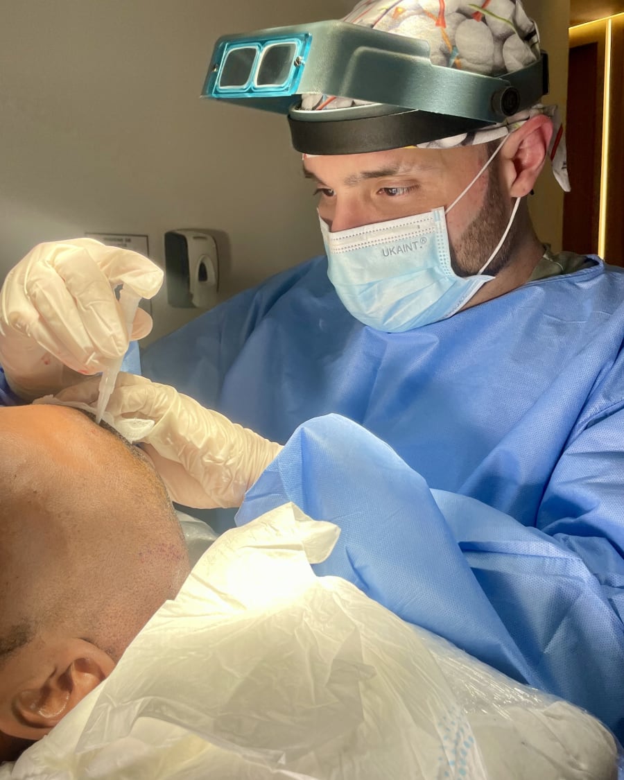 A Colombia Care surgeon working under loupes during a hair transplant in Medellín