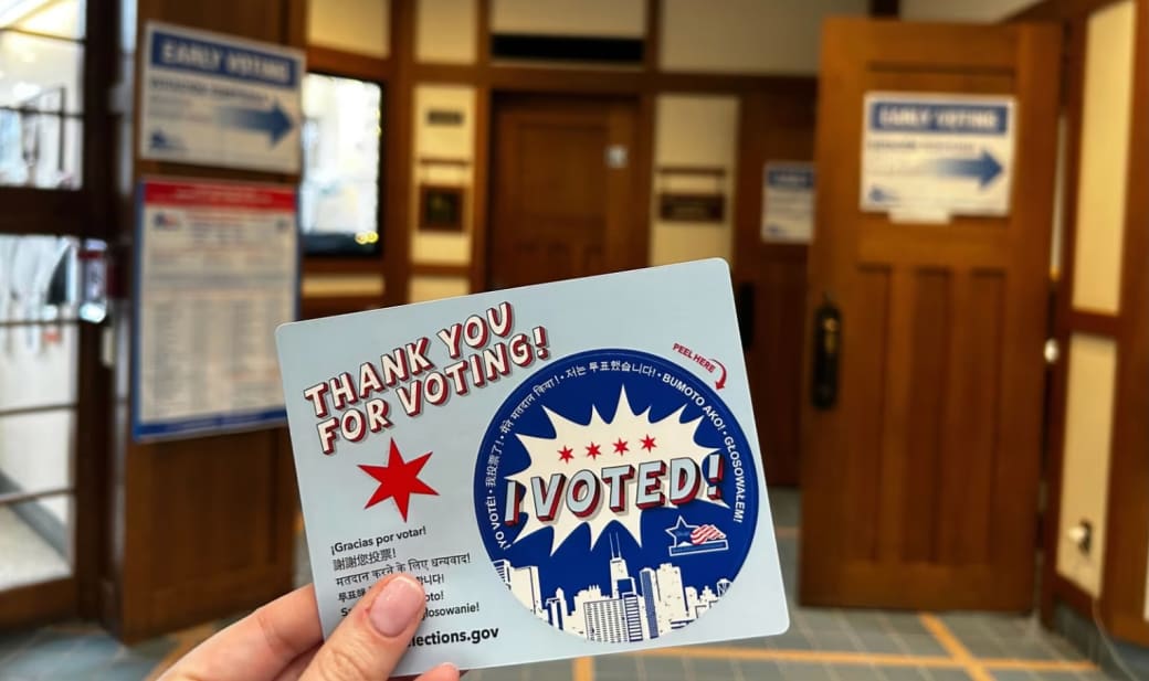 "I voted" sticker held up at a Chicago voting center.