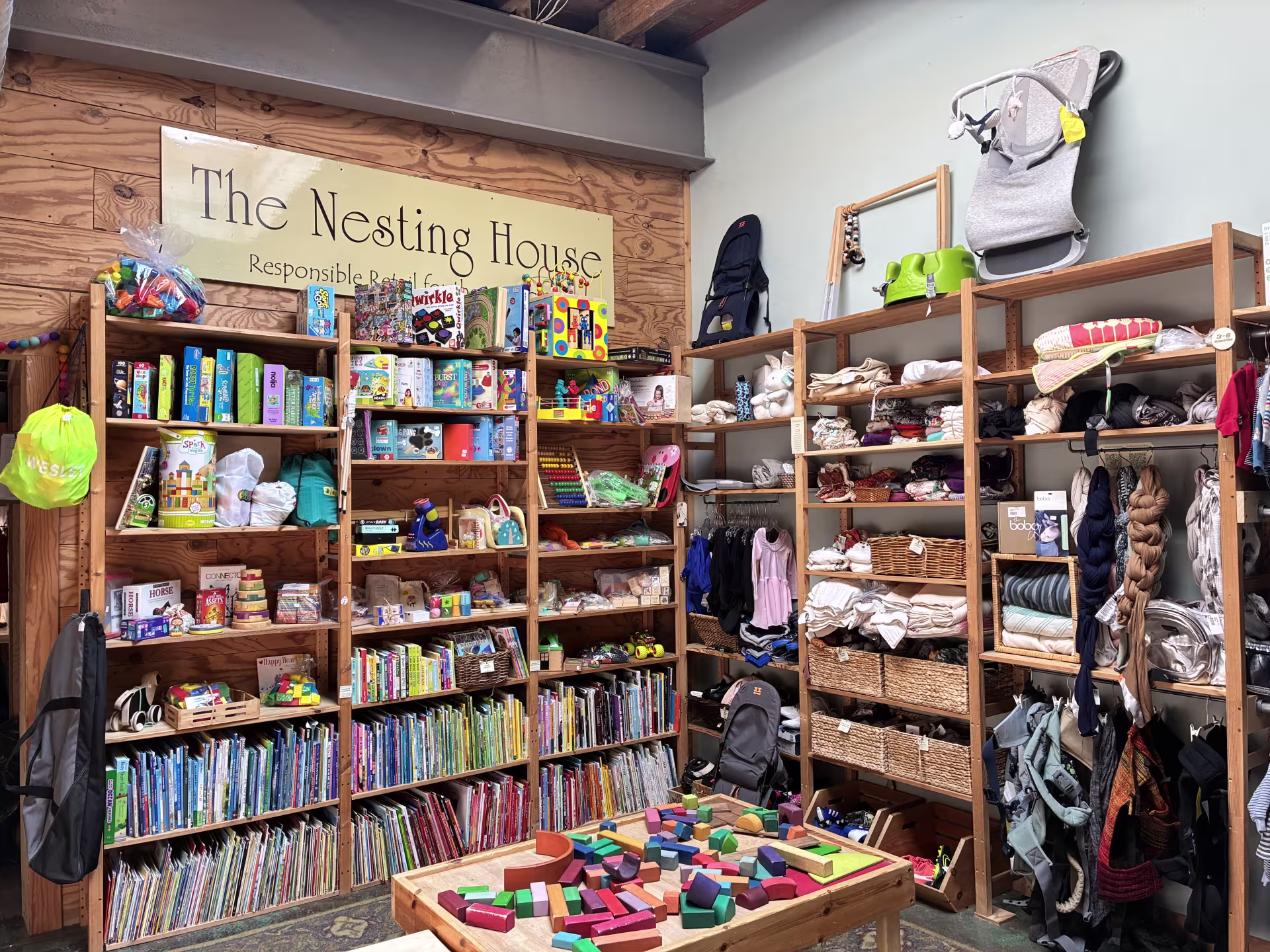 Wooden shelves of children’s books, toys, and clothing displayed at the Nesting House in Mt. Airy. 