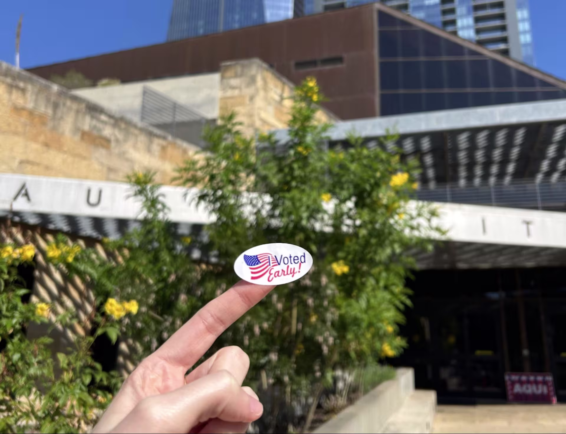 A person’s hand with a white “I Voted Early!” sticker on their finger.