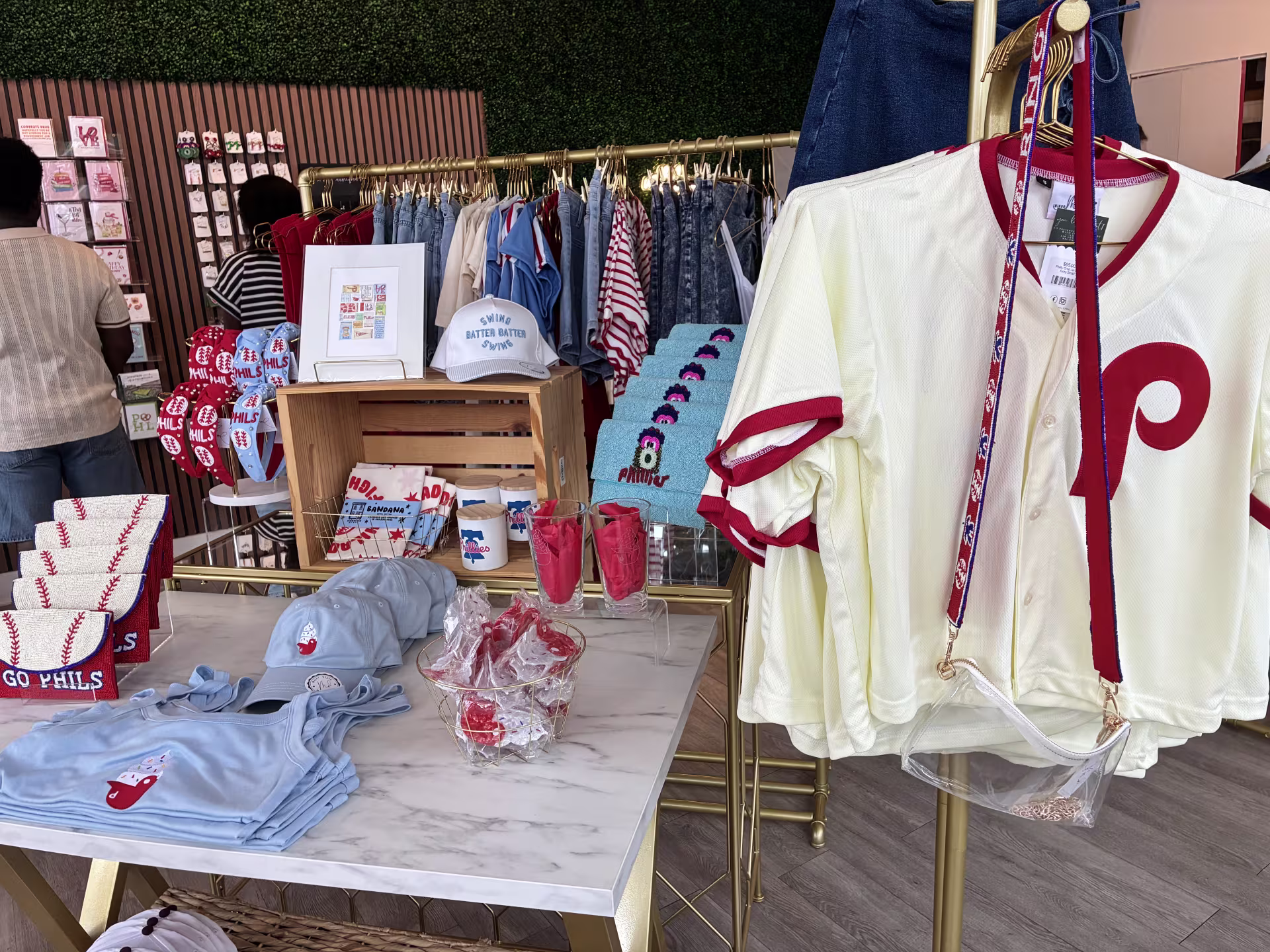 Display of Philadelphia Phillies jerseys, tank tops, hats, purses, and trinkets at Minor Details. 
