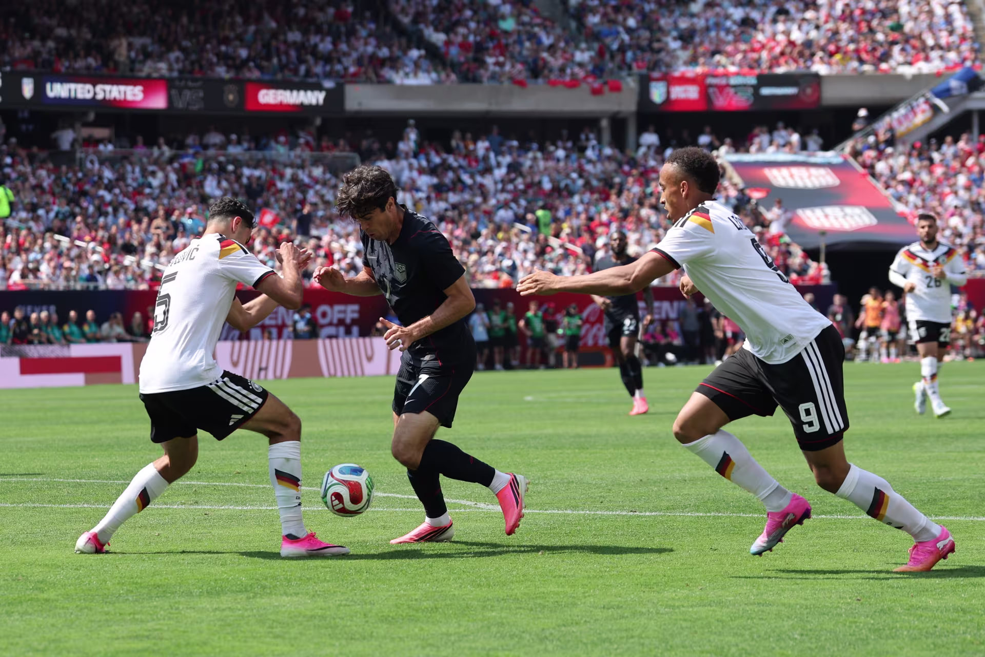People on a soccer field in a packed stadium playing a game of soccer