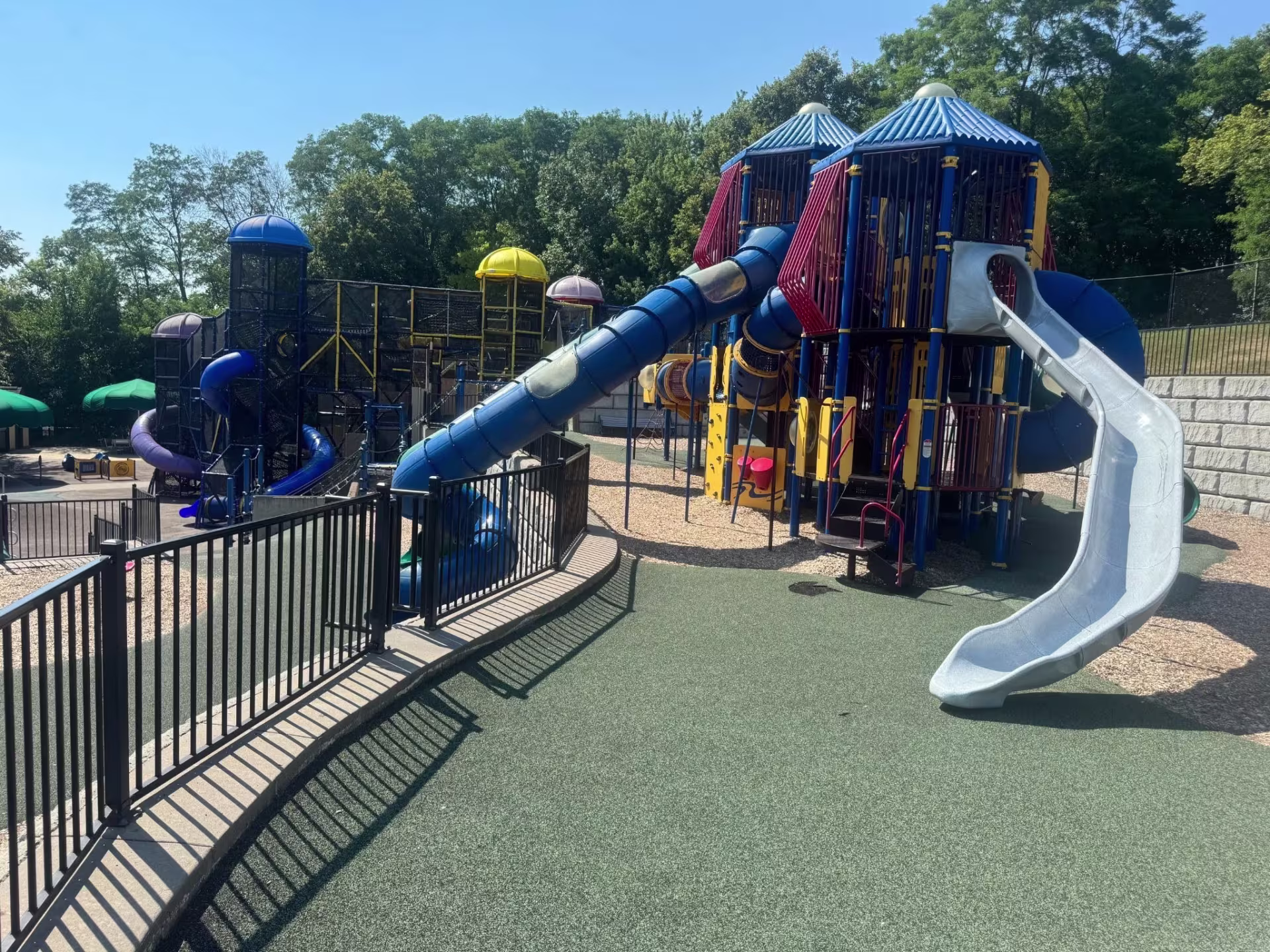 Empty children's playground with trees in the background on a sunny day