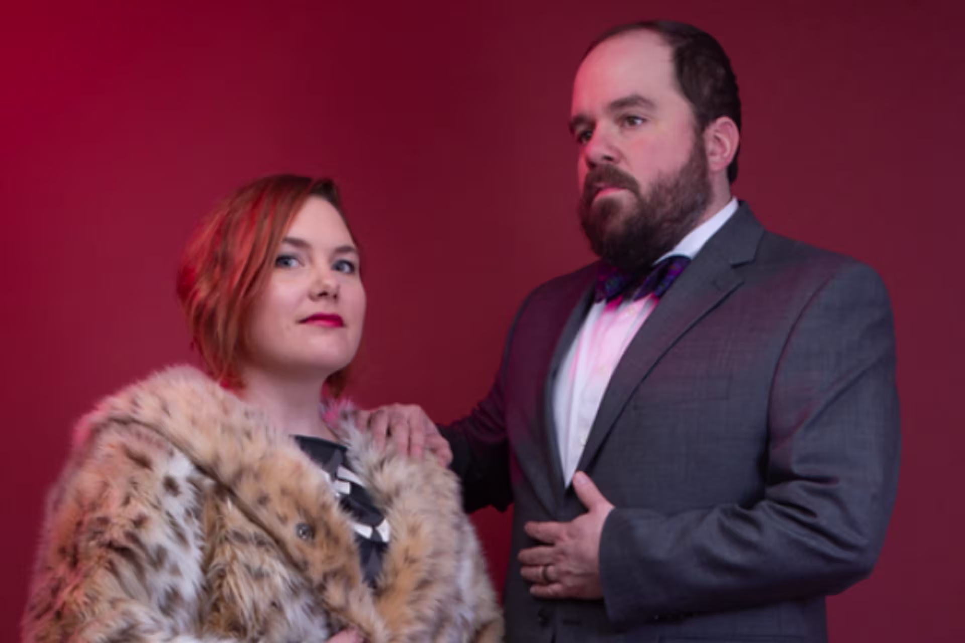 A woman in a leopard-skin coat and a man in a suit and bow tie.