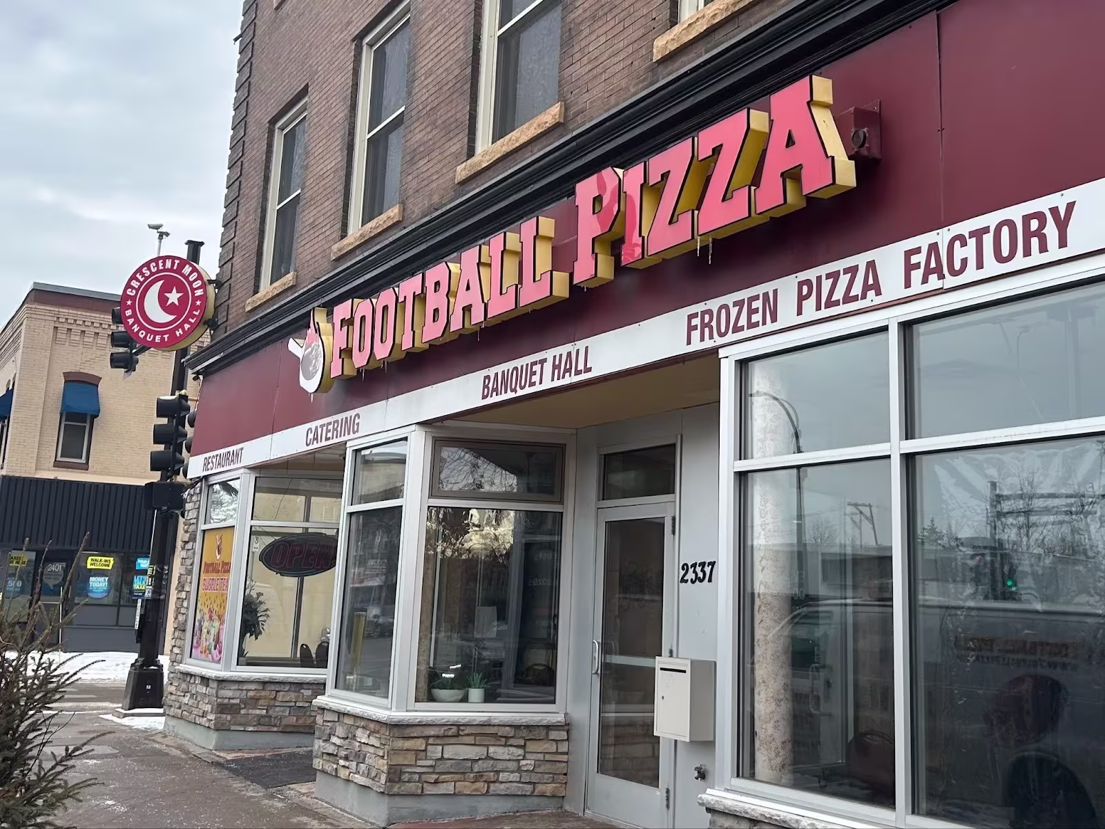 A building with a sign that reads "Football Pizza"
