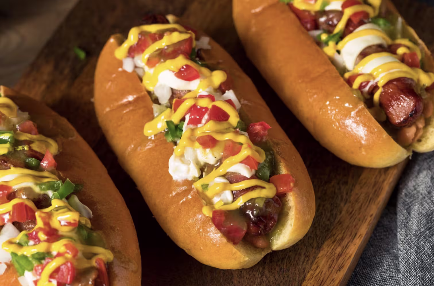 Sonoron hot dogs on a wood board.