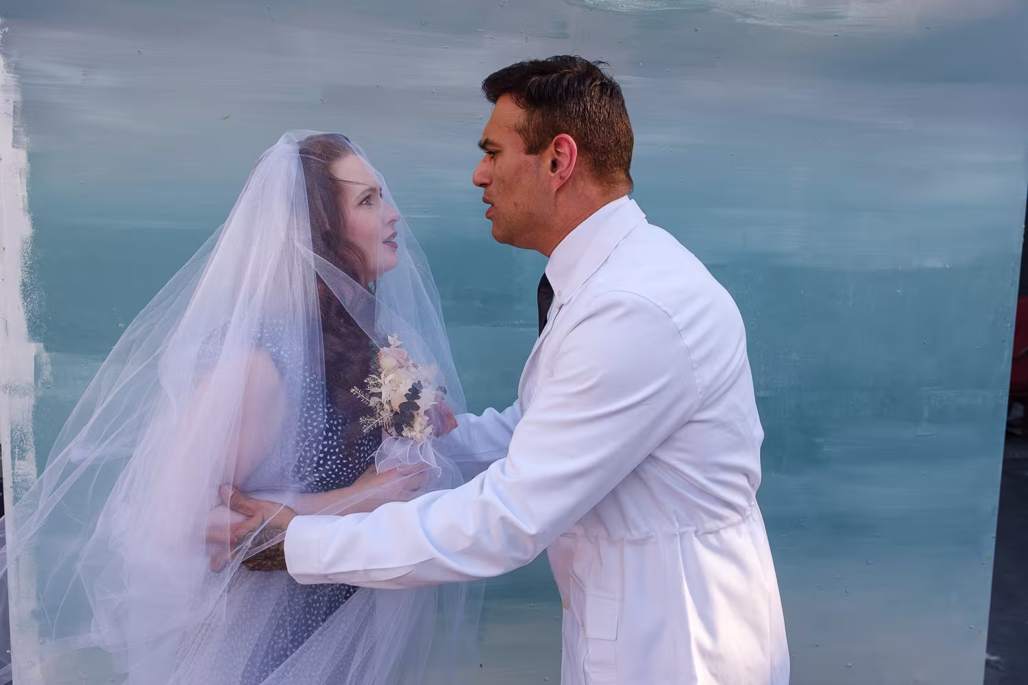 A woman wearing a veil looking at a man in a white shirt.