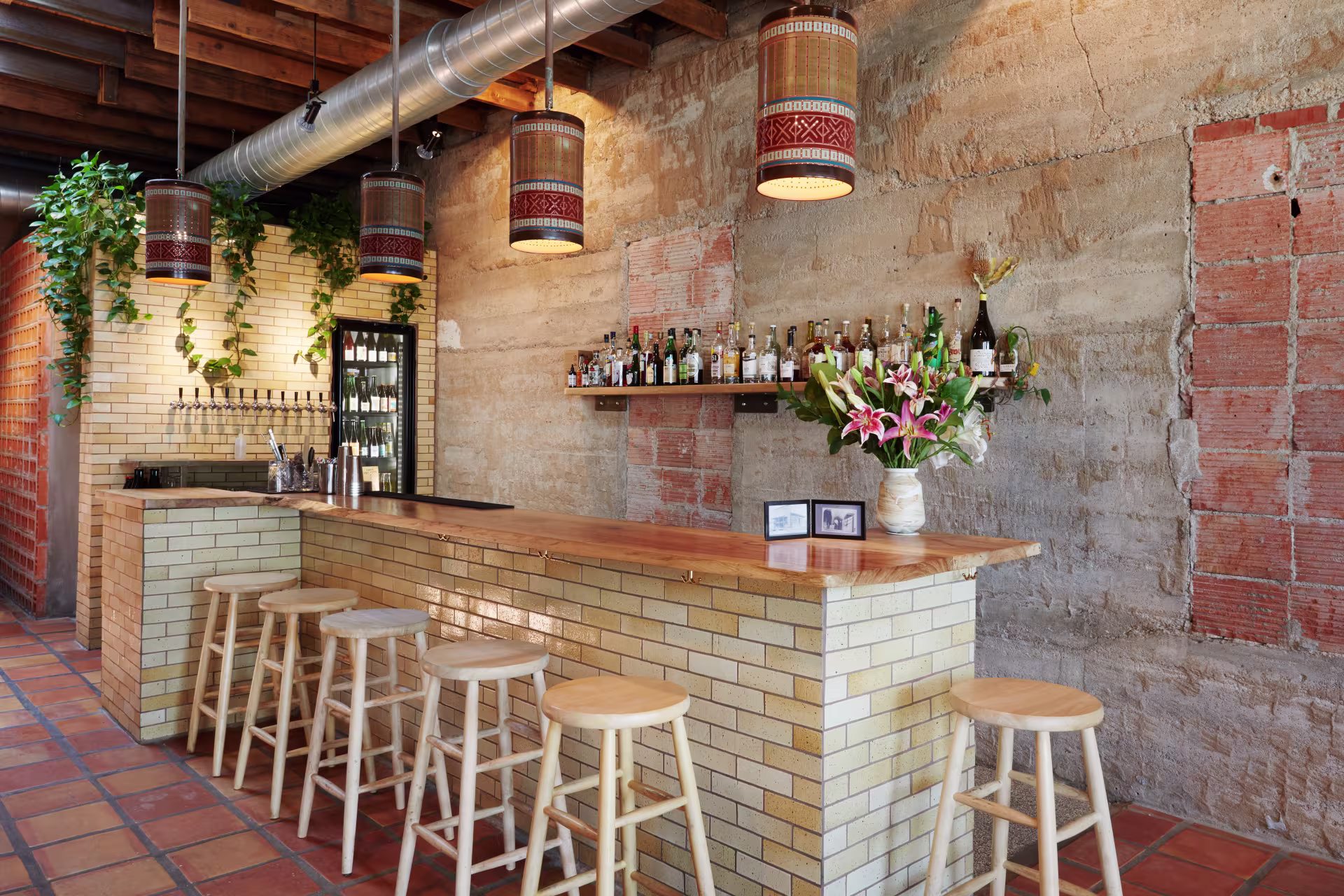 A bar made of white brick with a wooden table top.