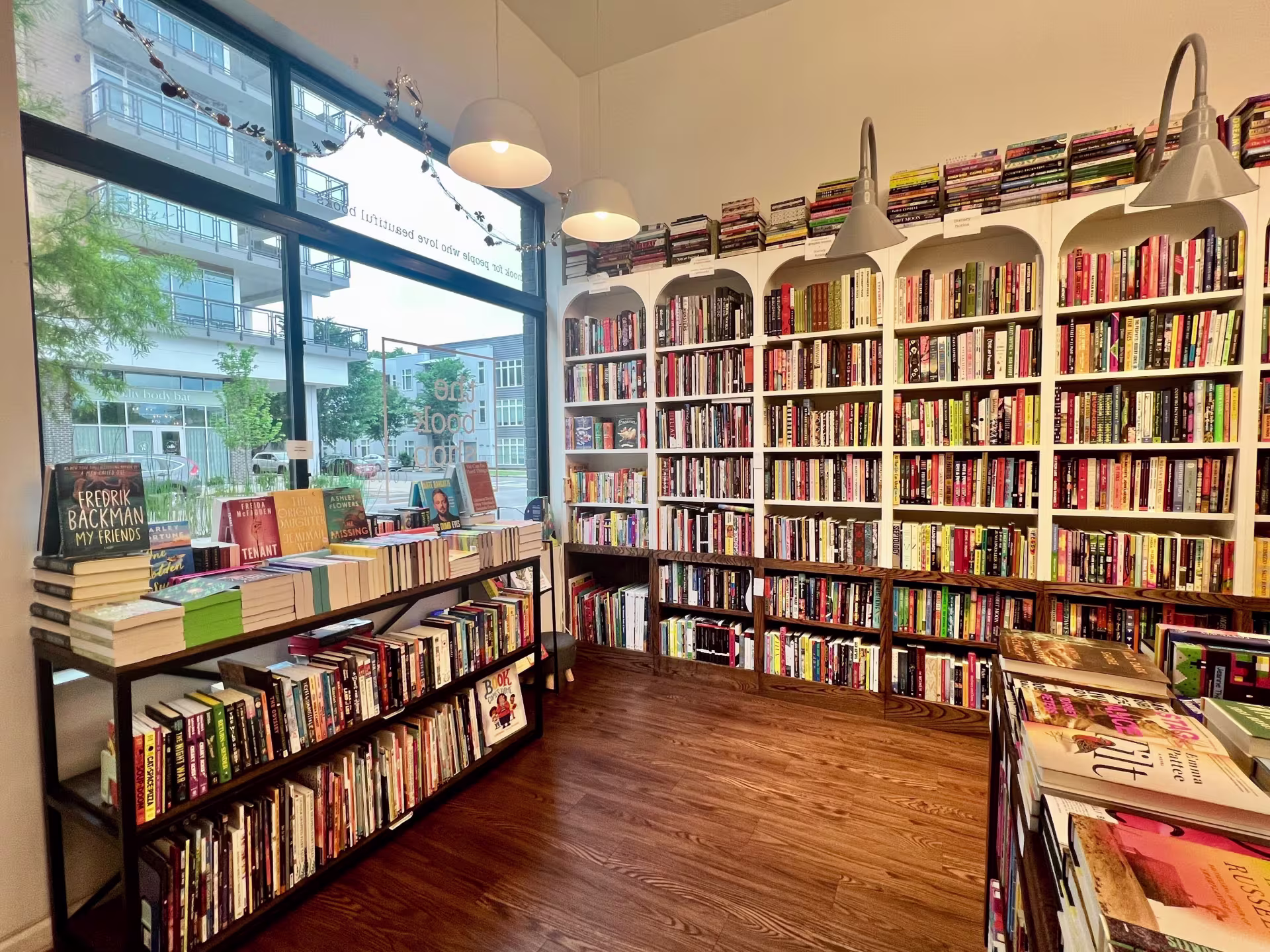 A bookstore with white shelves and wooden floors.