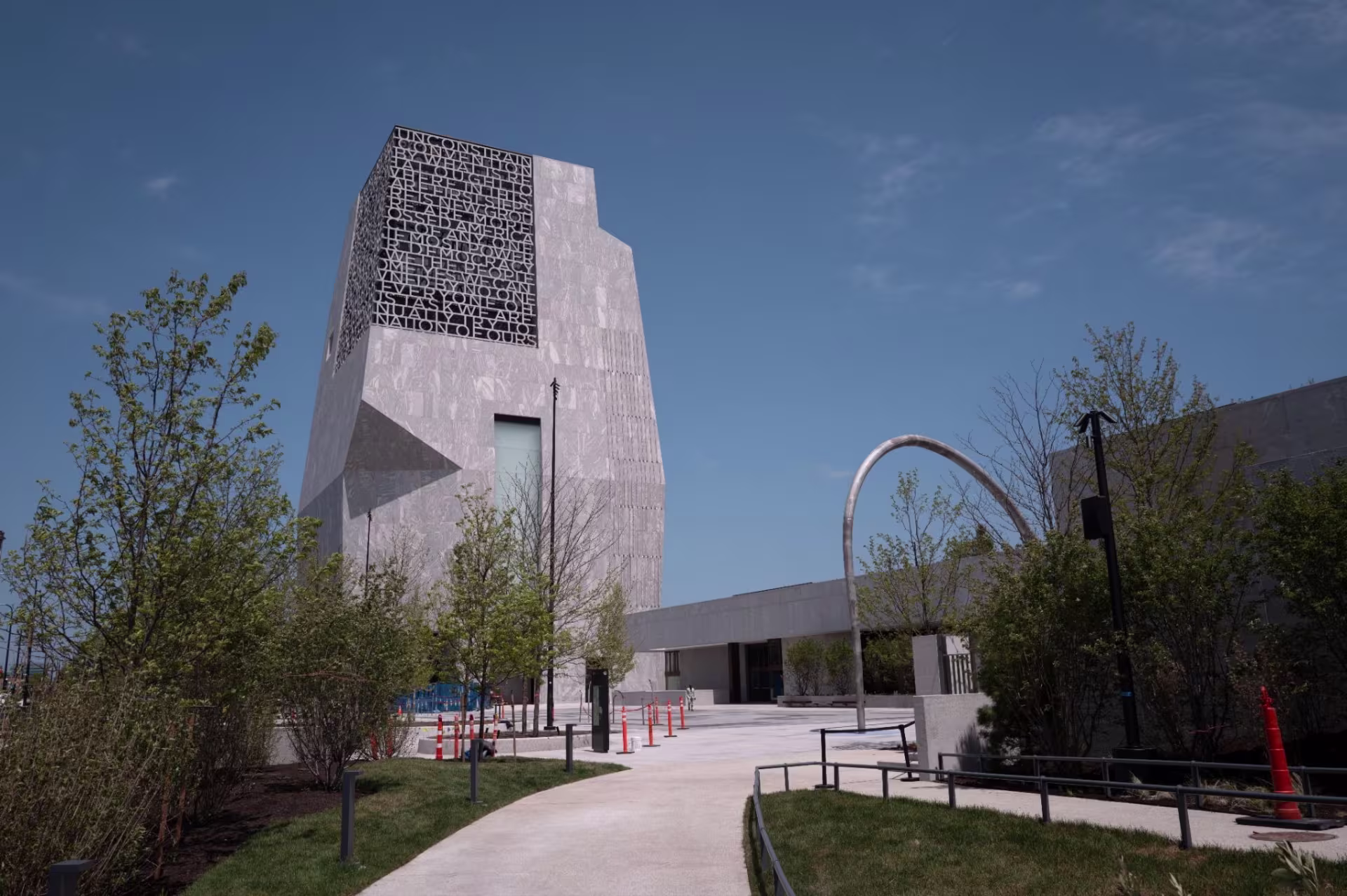 A tall grey brutalist building in a park