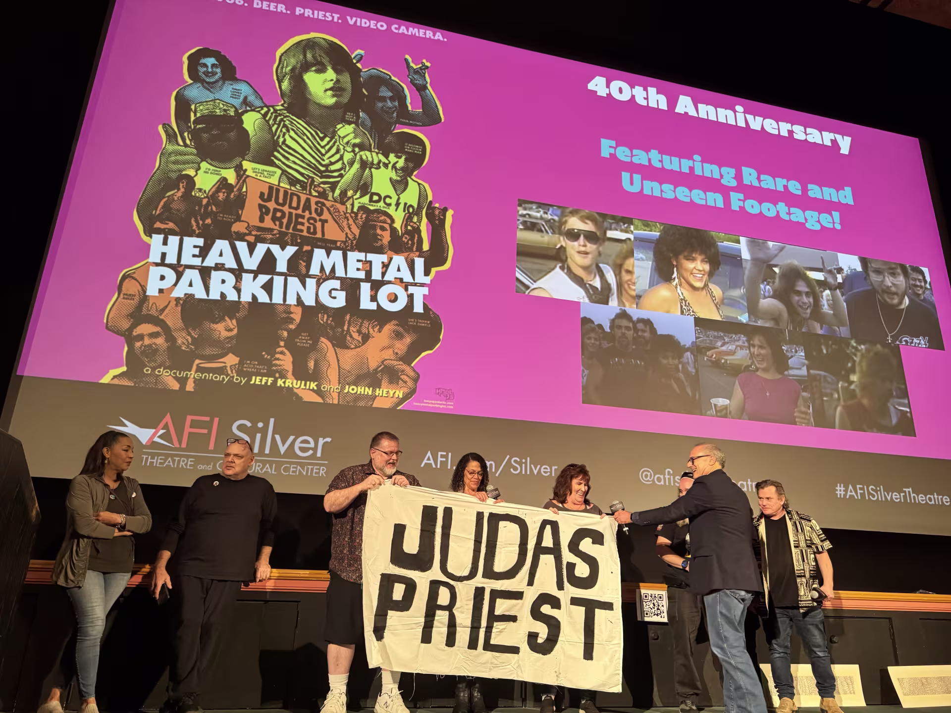 Filmmaker John Heyn brings out a Judas Priest banner at the 40th anniversary screening of Heavy Metal Parking Lot at the AFI Silver Theatre and Cultural Center in Silver Spring, Maryland. Heyn was joined by several people featured in the documentary. (Photo by Elana Gordon for City Cast DC)