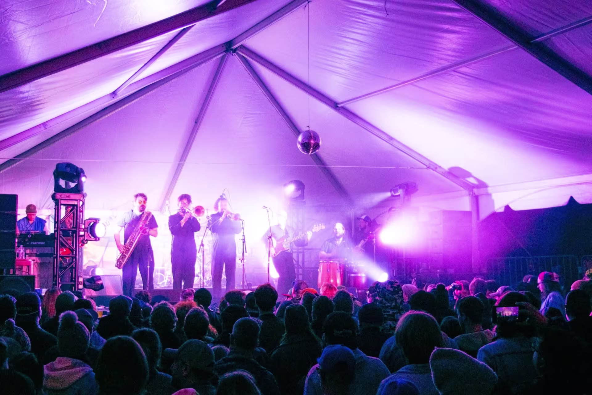 Band performs in front of crowd in a large tent
