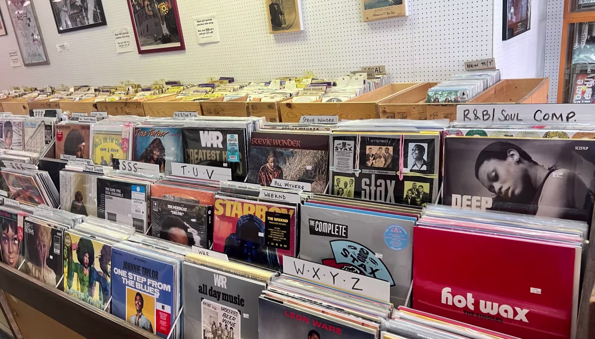 Alphabetized racks of vinyl records include an album from War and a Stax compilation