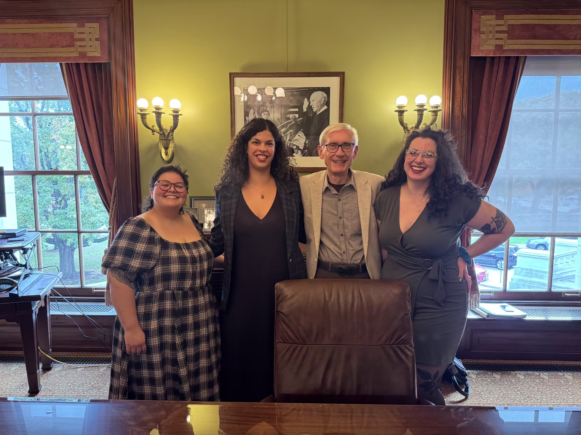 Four people standing behind a desk.