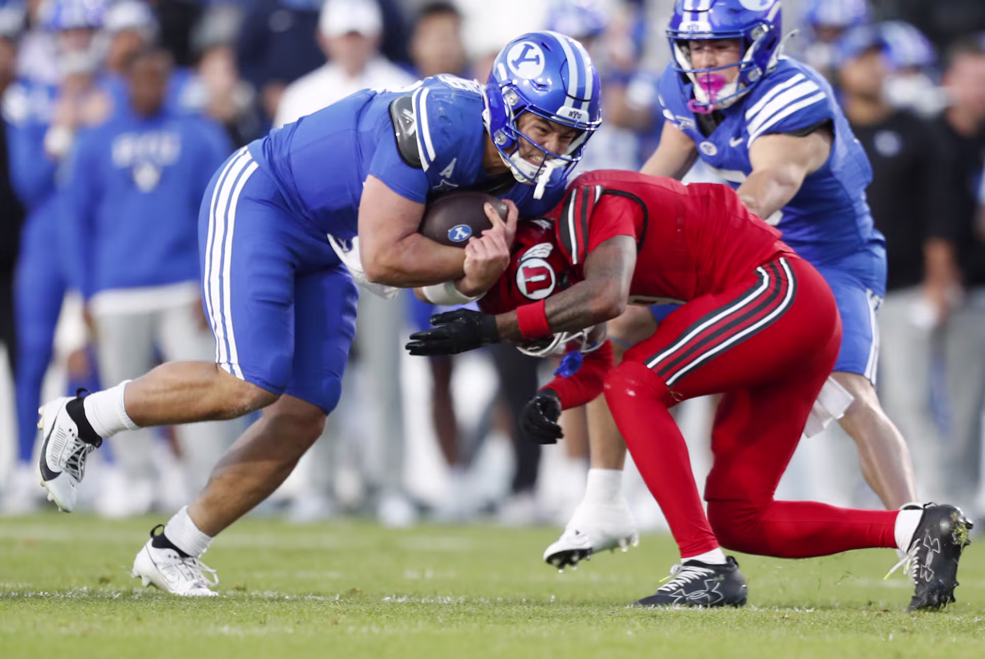Bear Bachmeier #47 of the Brigham Young Cougars is tackled by Elijah Davis #9 of the Utah Utes. 