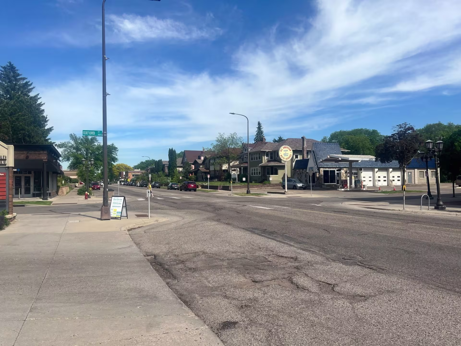 Urban street from eye-level, a few cars parallel parked in the distance, but otherwise empty of cars and pedestrians