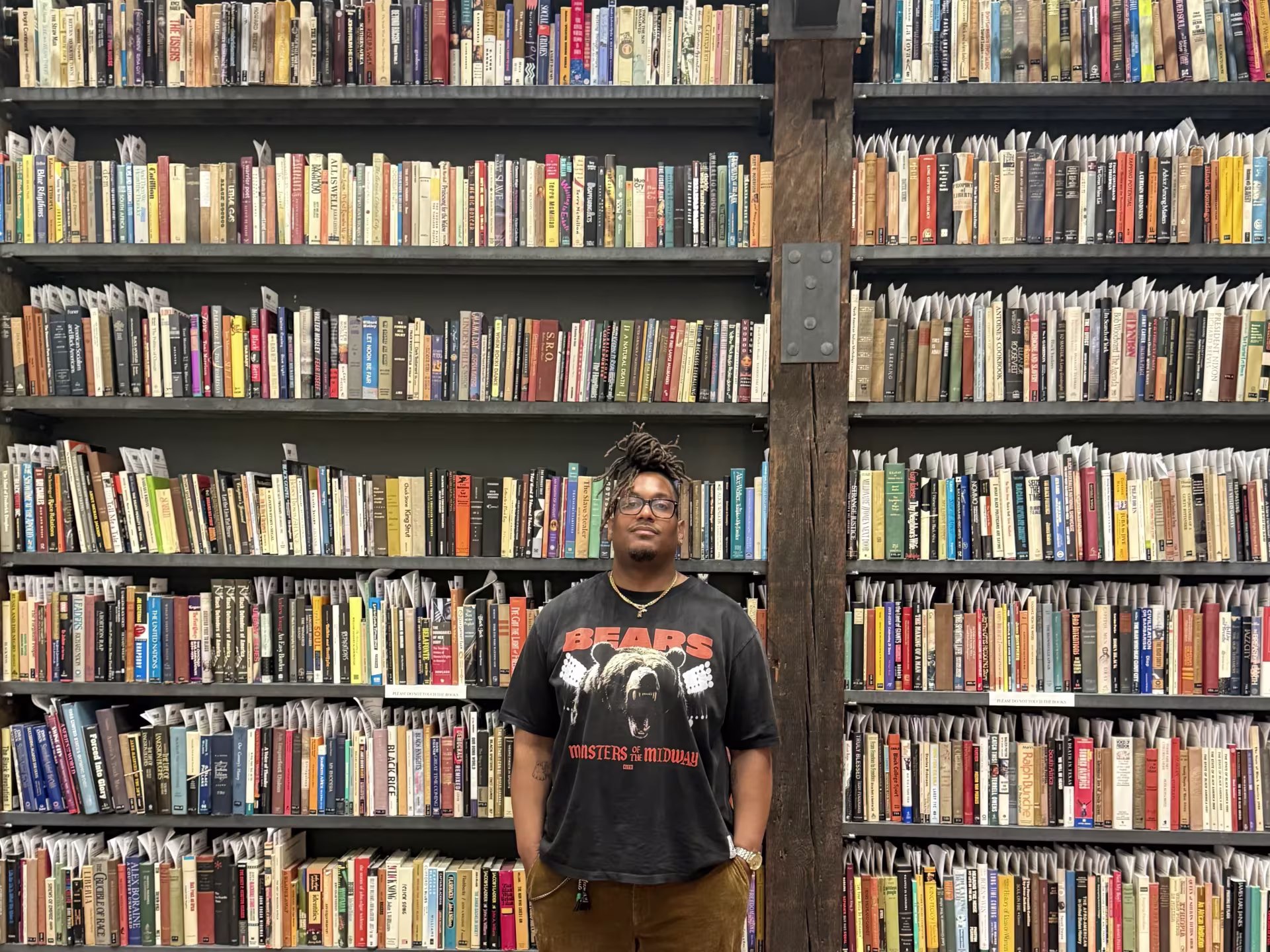 Man stands in front of shelves of books