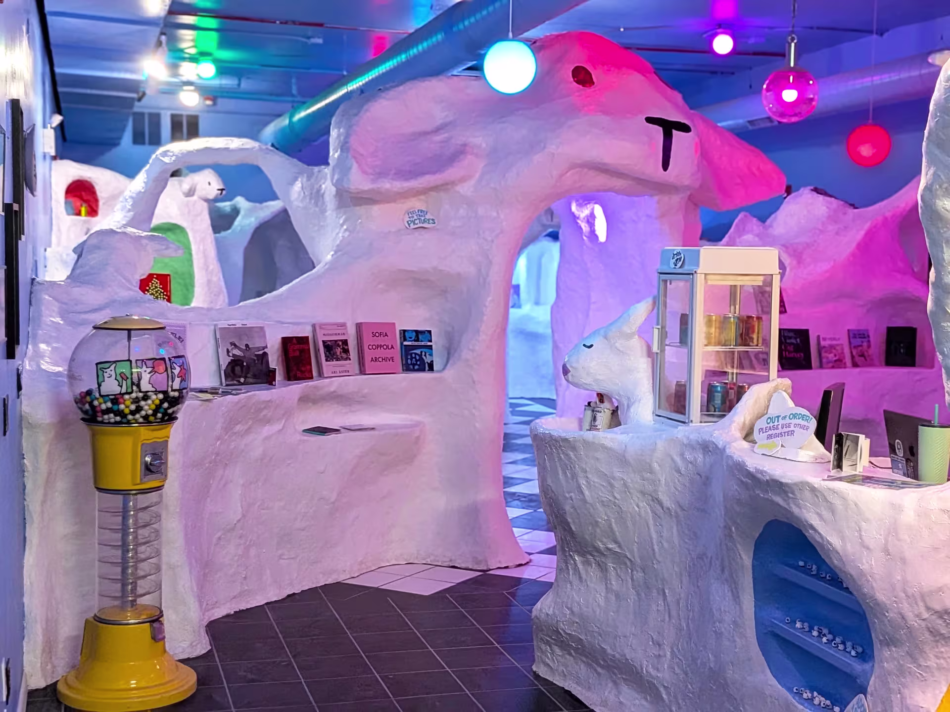 A large entrance in a store in the shape of a sheep. There are books along both sides of it