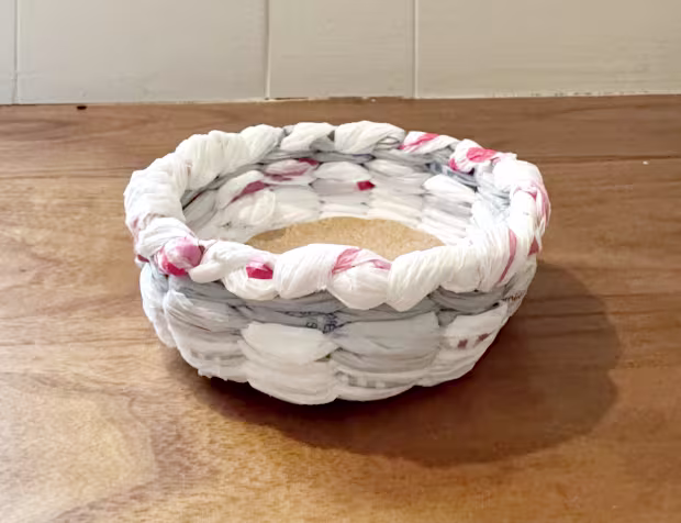 Small white, grey, and red basket placed on a wooden table