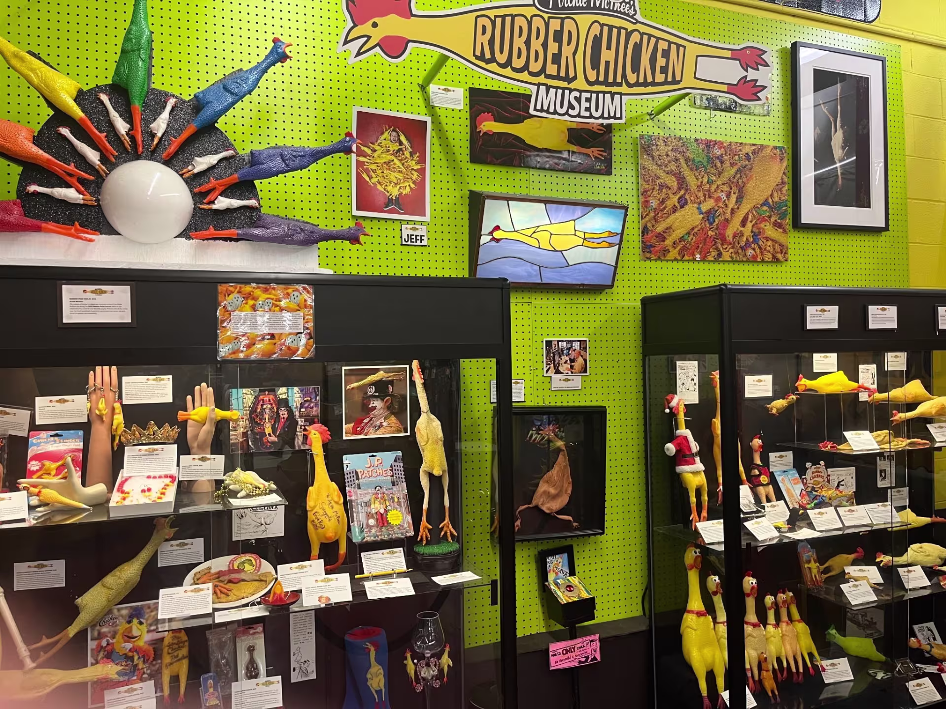 A lime green wall with an assortment of different rubber chickens