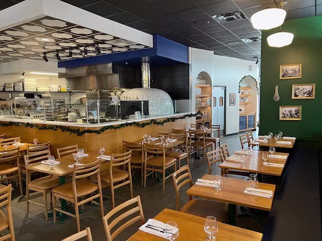 The interior of a restaurant with wooden tables and chairs. 