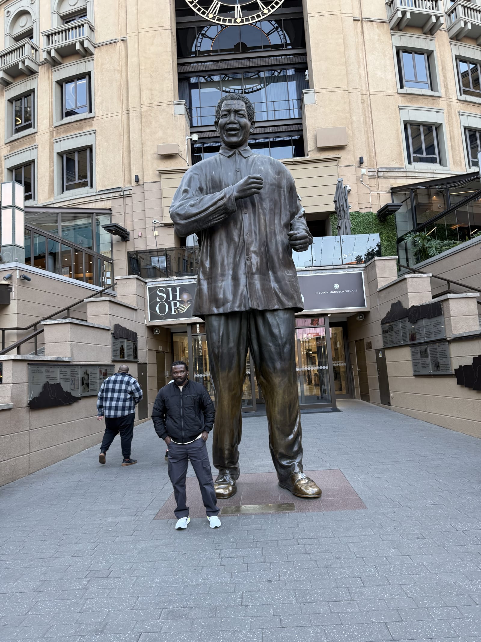Standing under the Nelson Mandela statue at Mandela Square, Johannesburg