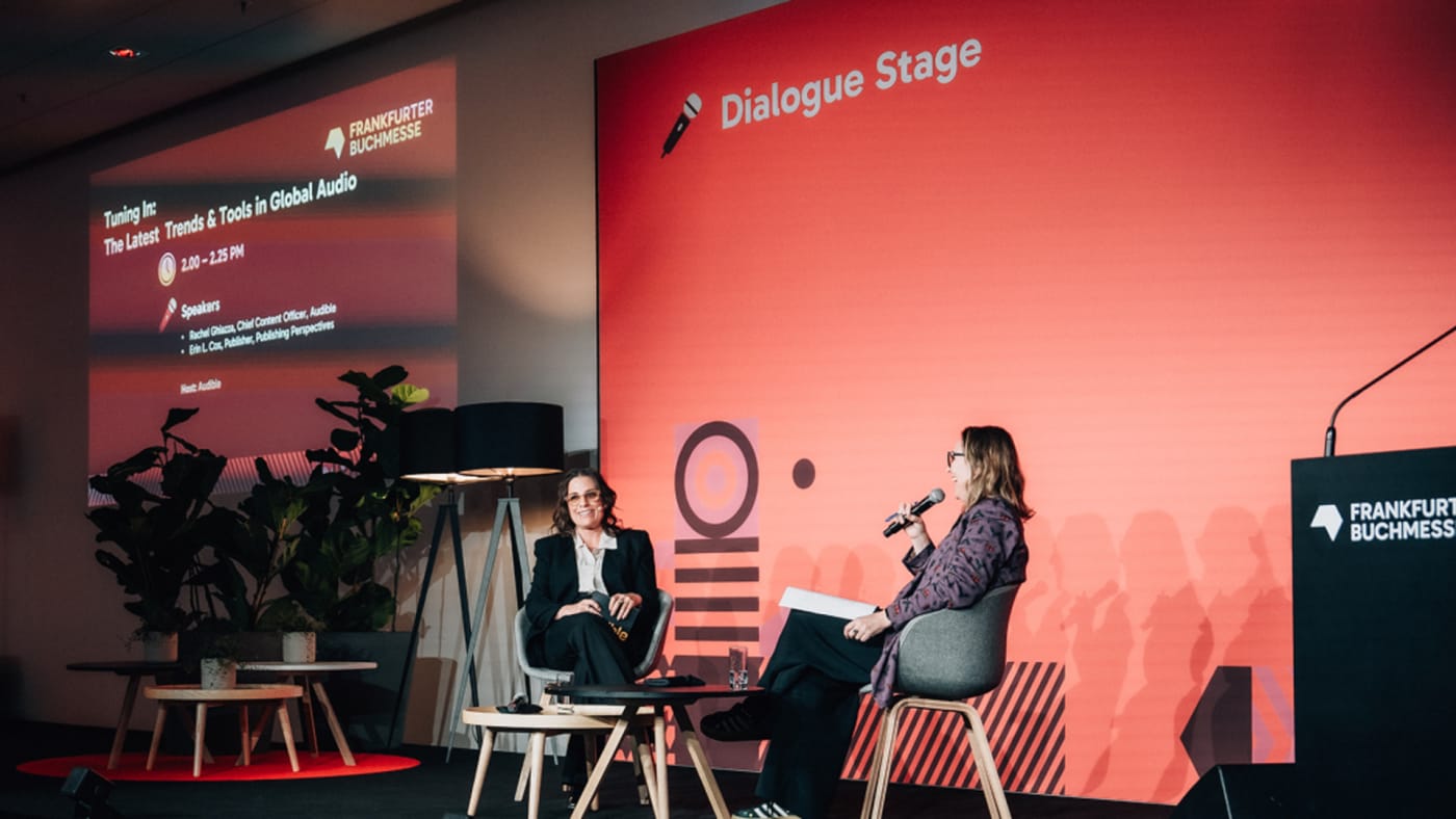 Duas mulheres conversam no palco Dialogue Stage durante painel da Audible na Feira do Livro de Frankfurt.