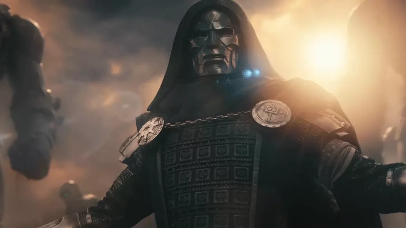 Doutor Destino vestindo traje escuro e máscara de metal, com Sentinelas ao fundo sob a luz do sol.