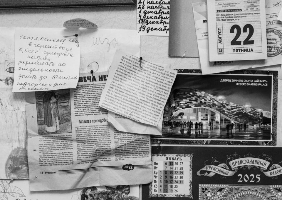 Mural com recortes de jornal e bilhetes escritos à mão presos por alfinetes.
