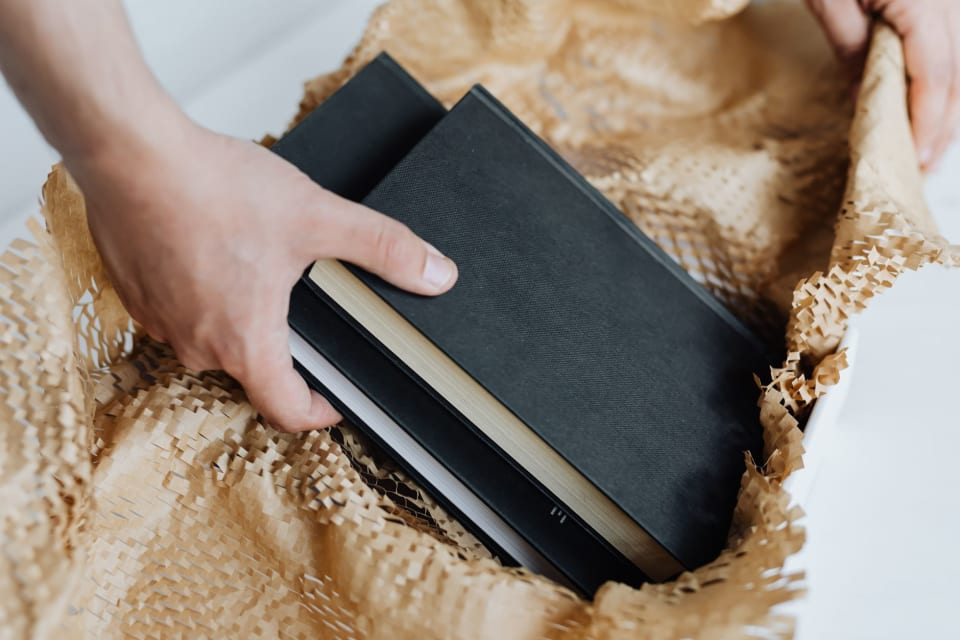Pilha de livros embrulhados em papel para envio