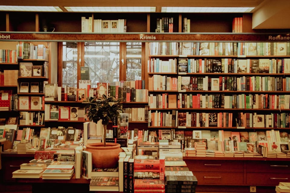 Prateleira de livraria com livros de lombadas variadas.
