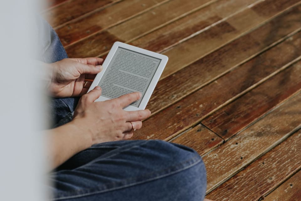 Pessoa lendo um e-book na tela de um tablet.