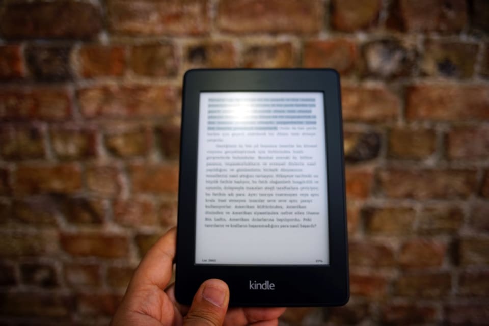 Leitor de e-book de tinta eletrônica com um trecho de texto na tela.
