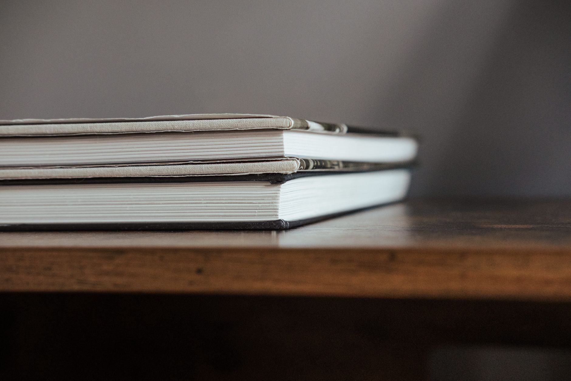 livro fechado sobre uma mesa de madeira com luz lateral